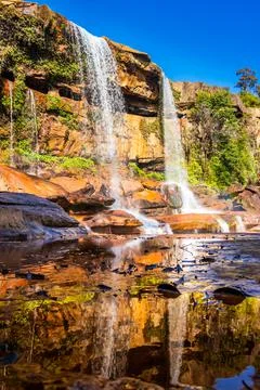 Waterfall falling from mountain top with reflection and blue sky at morning f Stock-Fotos
