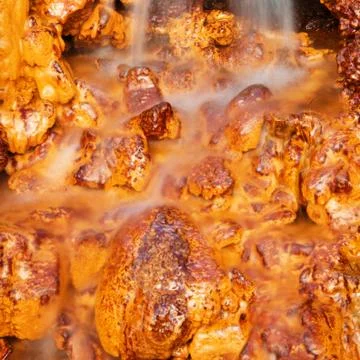 Waterfall falling on the orange and gold rocks Stock Photos