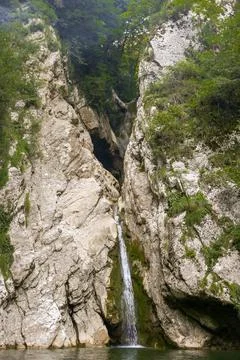 Waterfall falls from a cliff Stock Photos