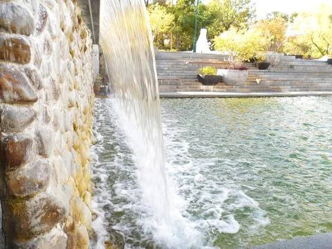 Waterfall Flow Over Stone Wall in City Park Stock Photos