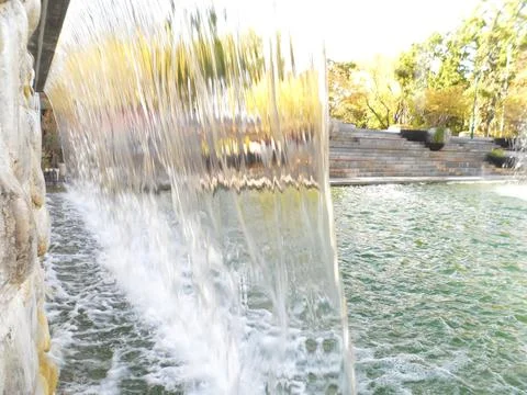 Waterfall Flow Over Stone Wall in City Park Stock Photos