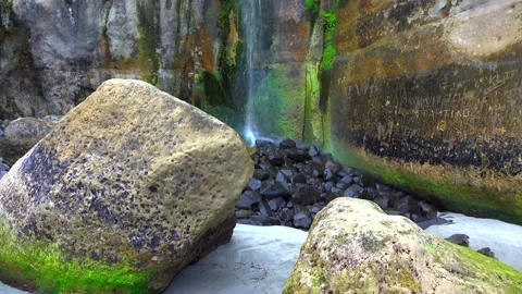 Waterfall flowing from a cliff that has sprouted green moss Stock Footage 131527385