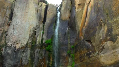 Waterfall flowing from a cliff that has sprouted green moss Stock Footage 131527405
