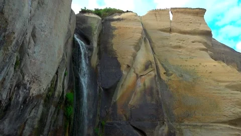 Waterfall flowing from a cliff that has sprouted green moss 스톡 동영상 131527452