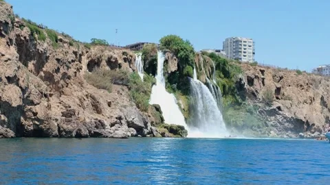 Waterfall flowing from a cliff into the sea in Antalya. Tourist boat visiti.. Stock Footage 333554237