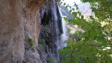 A waterfall flowing down from a high mountain Stock Footage 273680263
