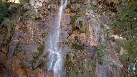 Waterfall Flowing Down Mossy Cliff Face Stock Footage 293238530