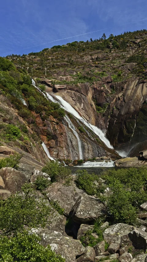 Waterfall flowing down rocky cliff Видео 338293809