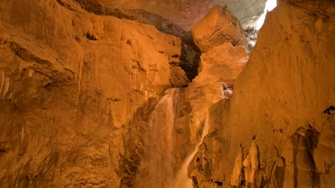 Waterfall flowing inside a massive limestone cave in Jiuxiang Scenic Area China Video stock 342278179