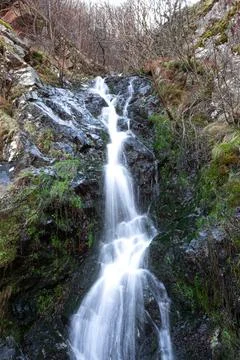 A waterfall flowing from the mountain Stock Photos