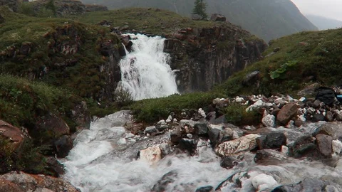 Waterfall flowing in the mountains of rocks and green grass of Iceland misty Stock Footage 112161454