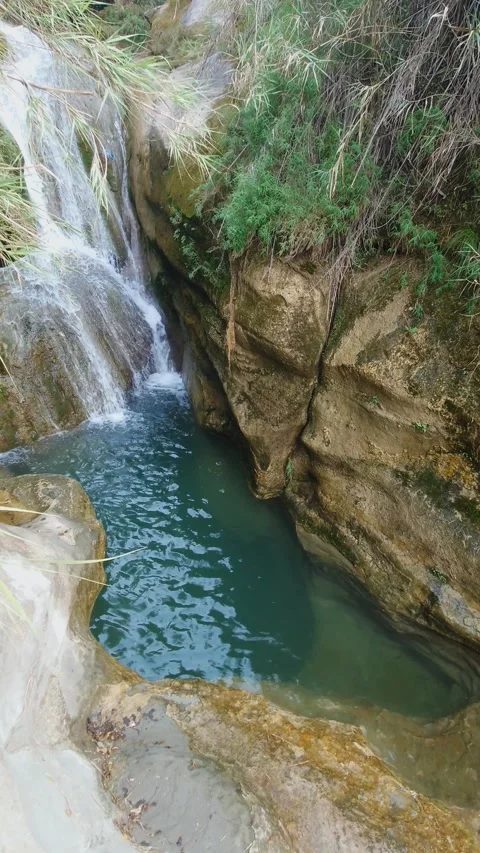 Waterfall Flowing Into Natural Rock Pool In Mountain Landscape - Vertical Stock Footage 343437589