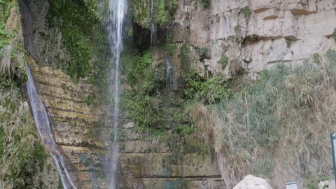 Waterfall flowing over a rocky ledge into a gorge Stock Footage 124027547