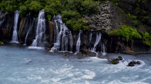 Waterfall flowing into the river Stock Footage 73011306