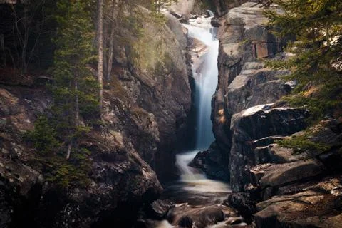 Waterfall flowing into a stony brook Stock Photos