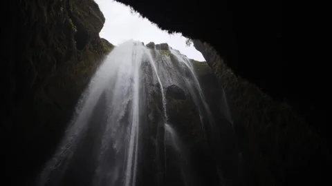 Waterfall Flowing Through Cave Opening in Iceland Stock Footage 317396761