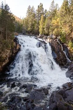 Waterfall flowing through the forest rocks in nature. Devil's Falls, Quebec. Stock Photos