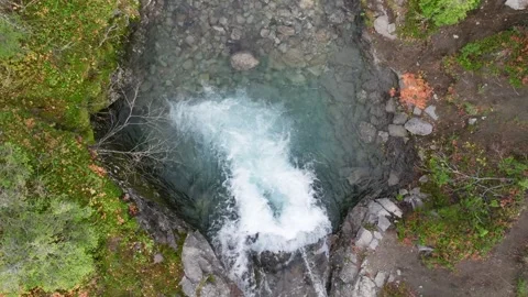 Waterfall flowing through rocky forest terrain aerial view Stock Footage 309322311