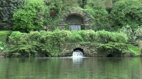 Waterfall Flowing Under Stone Bridge in Chiswick Gardens Stock Footage 76124742