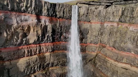 This waterfall flows beside towering basalt cliff formations Stock Footage 340267341