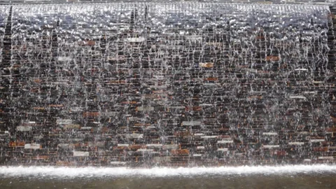 Waterfall flows down on a brick wall in park, Background, Germany Stock Footage 205122337
