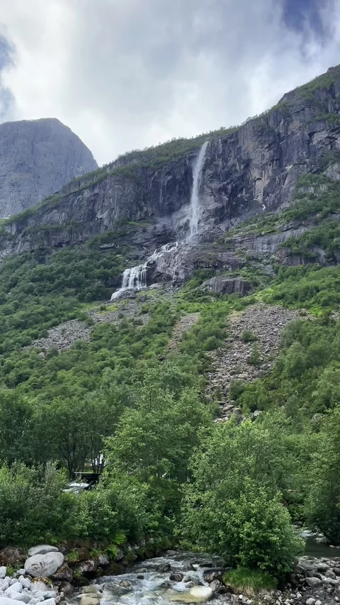 A waterfall flows down from the mountains of Norwa Stock Footage 337364966