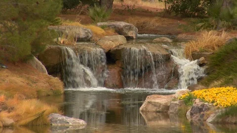 Waterfall flows down rocks into pond Stock Footage 125344929