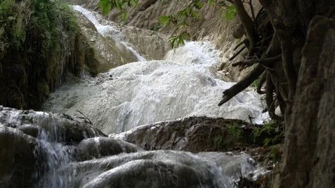 A Waterfall Flows down Tiers of Rocks in the Jungle Stock Footage 74292129