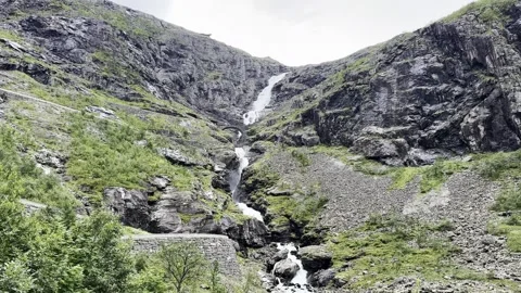 The waterfall flows down from the Trollstigen moun Stock Footage 317246277