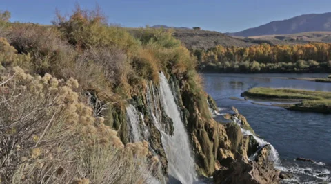 A waterfall flows into an Idaho river Stock Footage 36321091