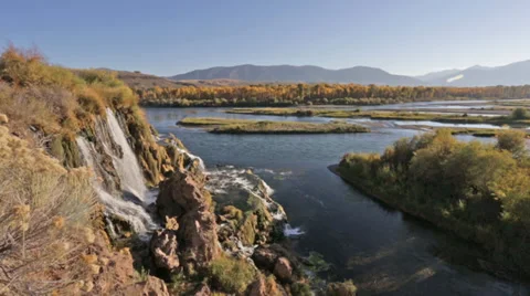 A waterfall flows into an Idaho river Stock Footage 36321121
