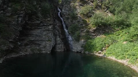 Waterfall  flows to the lake from the mountains Stock Footage 281650484