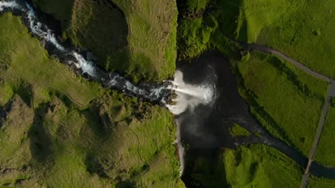 Waterfall flows into a lush green valley during daylight 스톡 동영상 320338558