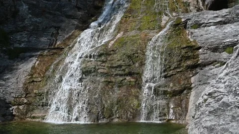 A waterfall flows over rocks into a pool (slow motion) Stock Footage 219644900