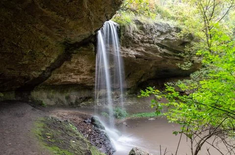 Waterfall flows over two huge rocks Stock Photos