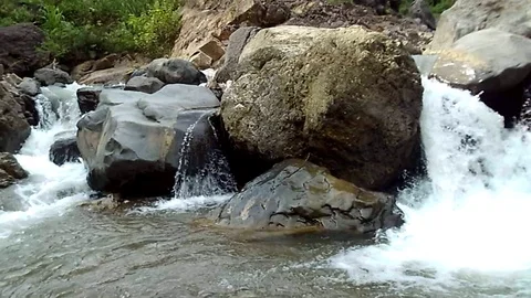 Waterfall flows in a river between large rocks Video stock 123948321