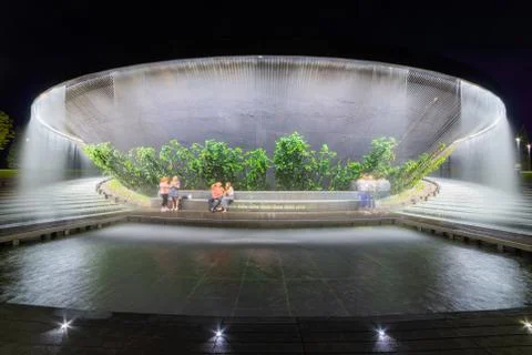 Waterfall flows in streams into granite bed of artificial river. Fountain in  Fotos Stock