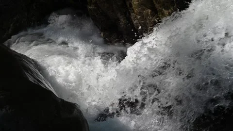 A waterfall flushes between rocks and creates bubbles (slow motion) Stock-Footage 219396425