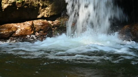 A waterfall flushes into a pool and creates many bubbles Stock-Footage 219393203