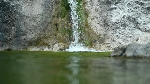 Waterfall flushing into a natural pool with green water (slow motion) Stock Footage 211762980