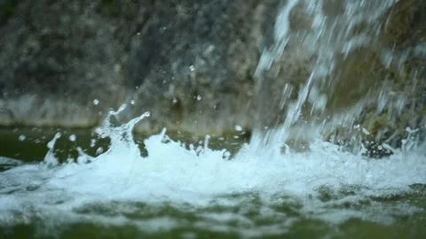 Waterfall flushing into a natural pool in the mountains (slow motion, close up) Video stock 211761672