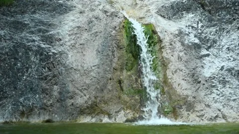 Waterfall flushing over rocks into a natural pool with green water (slow motion) Stock-Footage 211762949