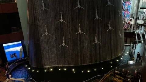 Waterfall with Flying Diving Men inside Dubai Mall. Stock Footage 154163492