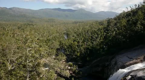 Waterfall in foreground with distant mountain range Stock Footage 11235781
