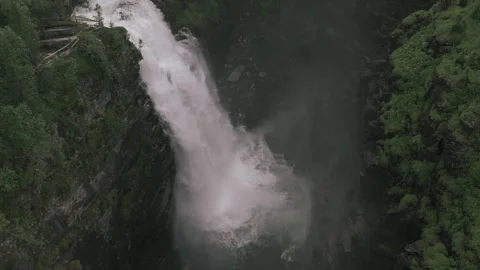 Waterfall in the forest canyon captured in slowmotion tilting down and going Stock Footage 255399987