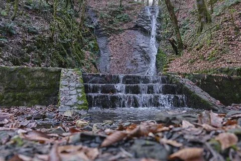 Waterfall in the forest flows down the stone steps Stock Photos