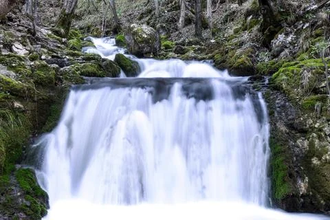 A waterfall in a forest with long exposure time Stock Photos