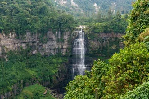 Waterfall in a forest with mountains Stock Photos