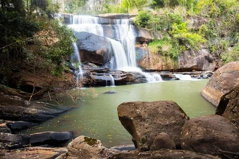 Waterfall in forest with rock foreground Stock Photos