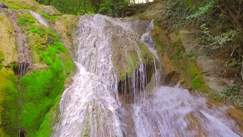 Waterfall in the forest, streams of water flow down mossy rocks and rocks Stock-Footage 78939759
